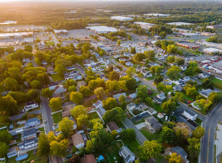 Incredible view from a height to a small town in houses and shopping mall of parking lot space at sunsetの写真素材