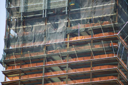 Modern building under construction with below of multi level commercial construction work site building close upの写真素材