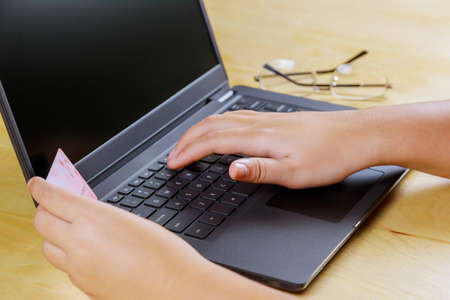 Online payment hand holding a credit card and working on laptop on Cyber Monday