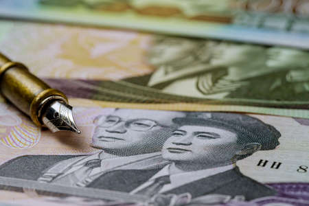 Various banknotes of North Korean won KPW, currency bill over pen for writingの写真素材