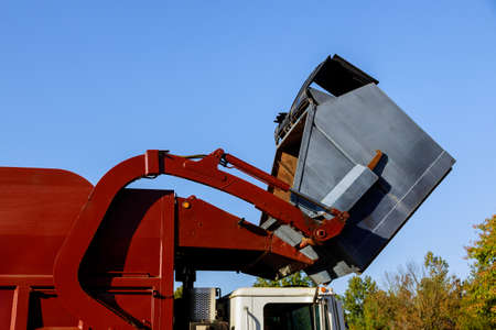 Work of public services for loading household waste from the container into the car the home...