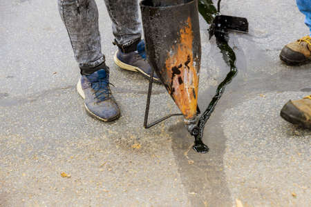 Road works on of asphalt during road repairs liquid seal coat mix asphalt