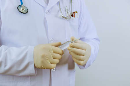 The medicine gloves doctor holding an ampoule for vaccination treatment in his hand focus on the ampouleの写真素材