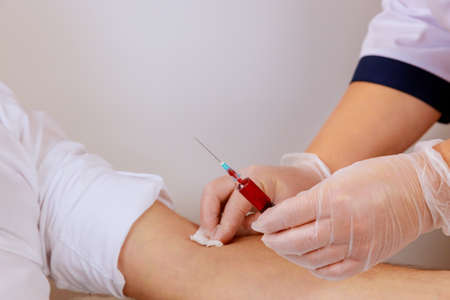 Laboratory nurse takes blood sample from arm on the analysis for dnaの写真素材