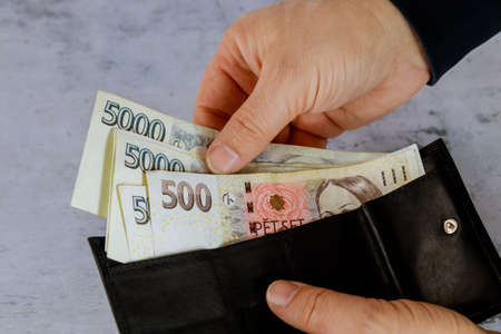 Man counts Czech korun in his wallet on Czech Republic banknotes