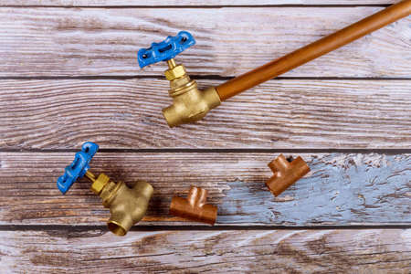 Set of brass plumbing fitting house improvement tools on wooden boardの写真素材