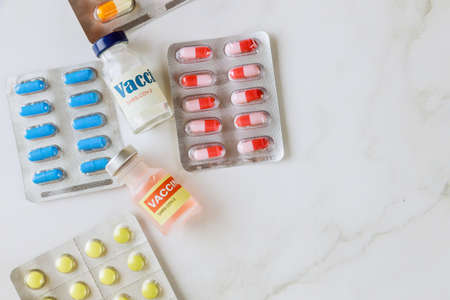 Many colorful pills tablets in the medical vaccination vaccine vial dose the new CoronaVirus...
