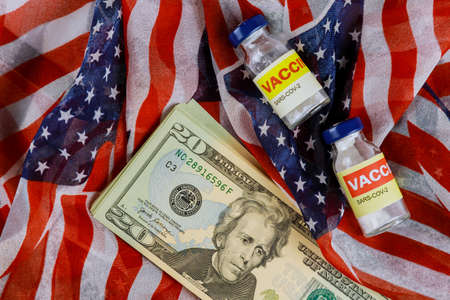 US dollar banknotes in the American vaccine in bottle and syringe for fight infection Sars-cov-2 coronavirus covid-19 with the USA flagの写真素材