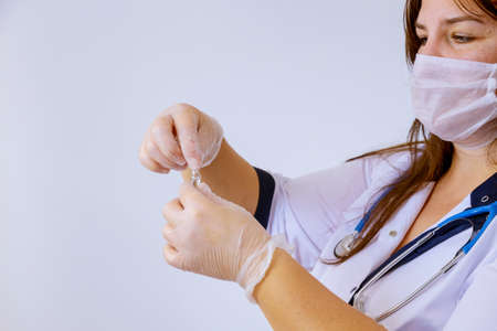 The medicine gloves doctor holding an ampoule for vaccination treatment in his hand focus on the...