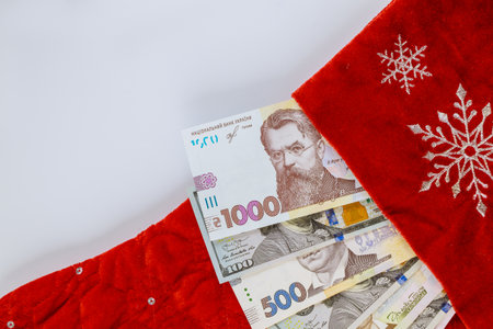 American one hundred US dollar bills and Ukrainian hryvnia in christmas red socks for gifts