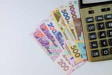 Financial accounting calculate the calculator on the Ukrainian money hryvnia banknotes with on white...