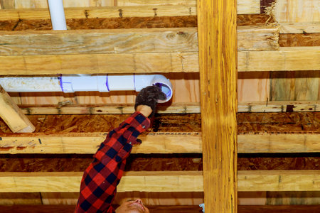 Hands plumber in installing of plastic drains PVC pipe, close up on new bathroomの写真素材