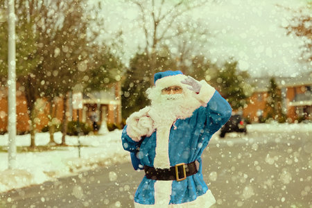Snow Santa Claus walking along the street carries a large bag of gifts on trees covered with snow the street during a snowfallの写真素材