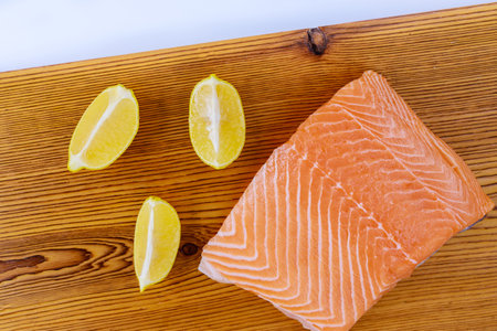 Fresh raw salmon fillet with wooden cutting board on a isolated white backgroundの写真素材