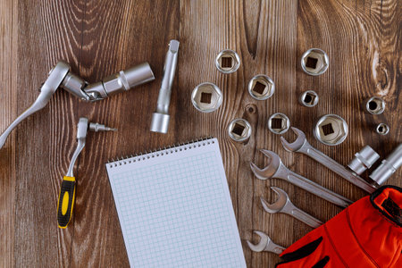 A set of hexagons of different sizes with set wrench from toolbox in a protective work glove a...