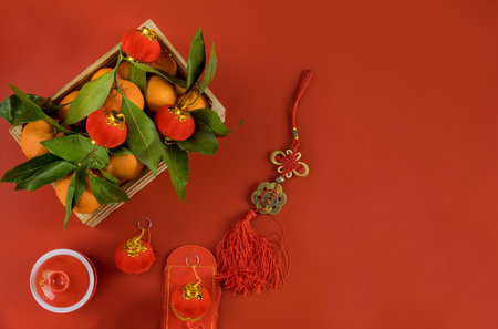 Decorations of accessories in Chinese New Year Ceremony festival in traditional container mandarin oranges on a red backgroundの写真素材