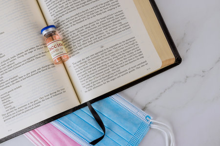 22 JANUARY 21 New York US 2021: Opened the Holy Bible close up prayer time with Negative attitude of the church to vaccination and covid-19 vaccine bottleのeditorial素材
