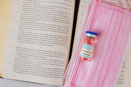 22 JANUARY 21 New York US 2021: Reading the Word of God the Bible Holy Book with attitude of the church to vaccination and Coronavirus covid-19 vaccine bottleのeditorial素材