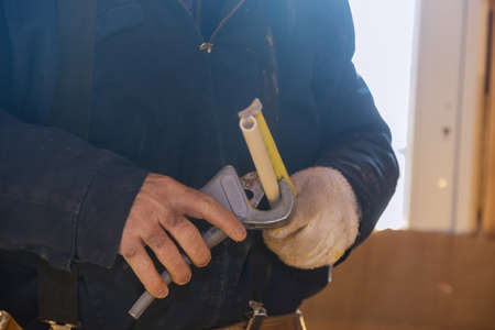 Worker cutting to measure cpvc pipe in construction site