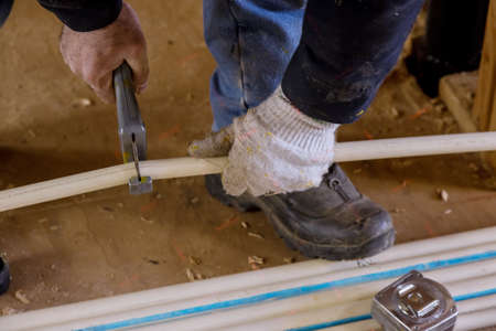 Plumber cutting in the pvc water lines pipe on new home under construction