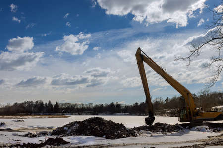 View from of the backhoe was digging a pit in the ground on winter