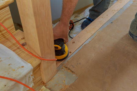Carpeted in refinishing in the stairwell of railing in a sandpaper sanding