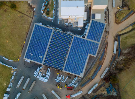 Solar panels installed on a roof of a large industrial a warehouse building.の写真素材