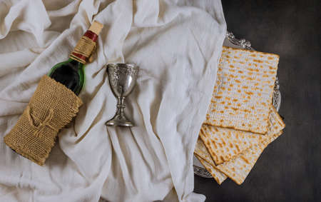 Passover holiday traditional celebration with cup wine kosher matzah unleavened bread on of Jewish...