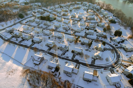American town on after snowfall USA aerial view of a winter day time in suburb city with snow covered of residential quarters by the riverの写真素材