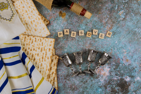 Matzoh jewish passover bread in the traditional four glasses Kosher wine holiday over wooden tableの写真素材