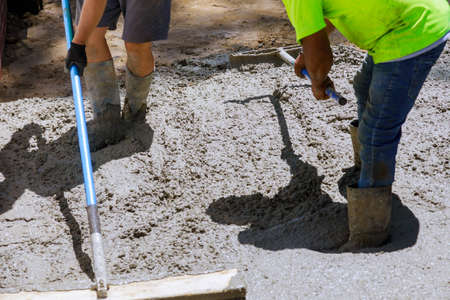 Workers concrete mixer with pouring cement during to residential sidewalk
