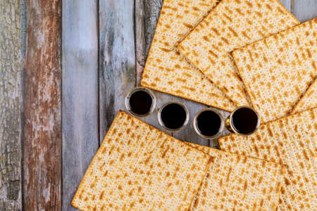 Passover holiday traditional celebration with four cup wine kosher matzah unleavened bread on of...
