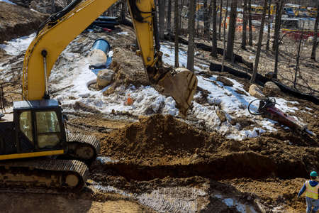 Excavator is digging a huge trench, ditch for drainage canal utility pipe pipeline installationの写真素材