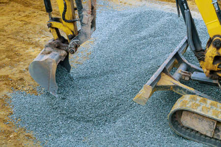 Industrial machinery construction site, excavator moving gravel and rocks for foundation buildingの写真素材