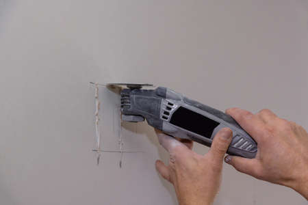 Angle hand electric power tools cut holes drywall sheet for electrician outlet
