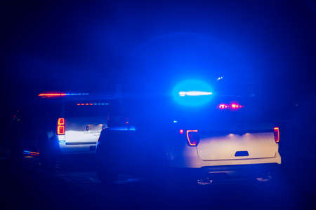 Police car with blue emergency lights on the crime scene environment.