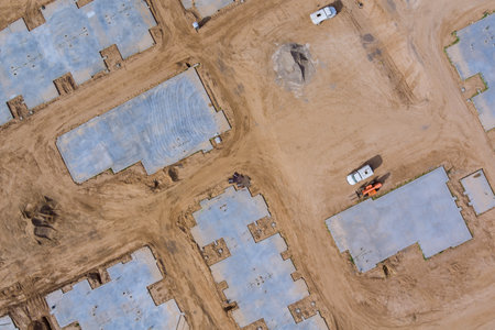 Aerial view on construction work in newly completed cement foundation of new residential district...