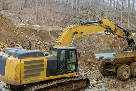 Tractor loads with stone a dump trucks transporting for processing stone