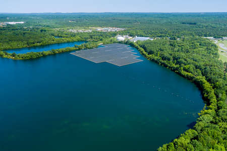 Aerial view of solar power station float on water lake, in the electric renewable ecological energy