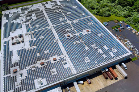 Panoramic aerial view on solar panels on factory roof absorb sunlight as a source of energy to generate electricity creating sustainable energyの写真素材