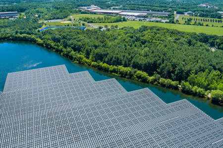 Panorama view on panels floating on water with floating solar panels in a blue pond under the...