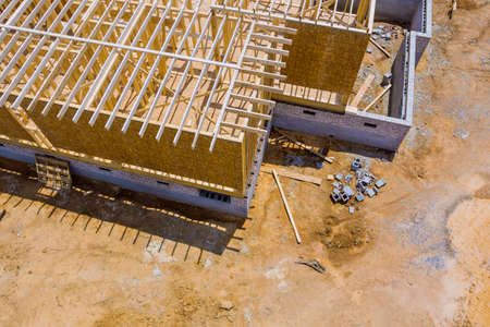 Beams under construction framing of a new unfinished wooden house at a construction site