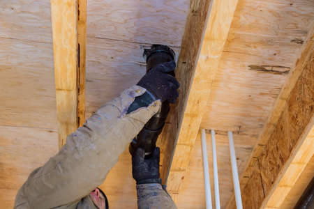 Hands plumber in installing of plastic drains PVC pipe, close up on new bathroom