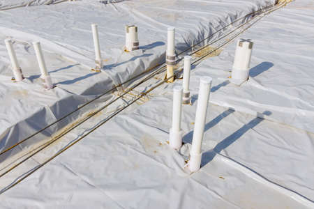 Plastic PVC water pipes industrial pipeline laid on sand foundation at construction siteの写真素材