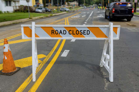 American road highway with improvement construction work site on Road closed warning safety sign on...