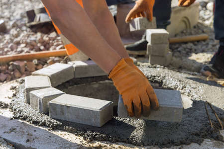 Sewerage construction with utility worker installing manhole sewage reconstruction a pit for a...
