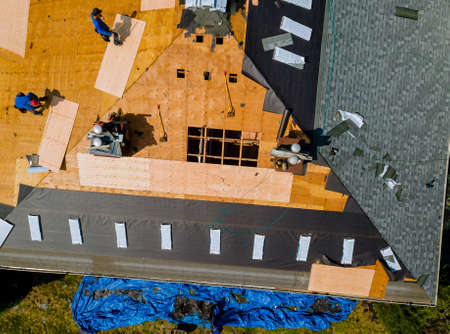 Removal of old roof and replacement roofs with new roof shingle being applied home roof construction...