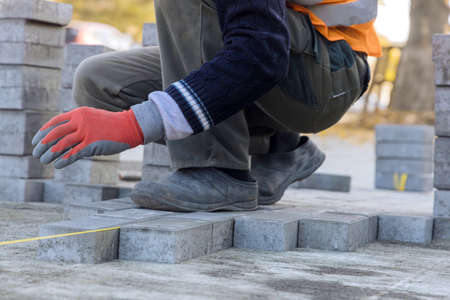 Installation of concrete bricks during sidewalk construction large construction site with repair workの写真素材
