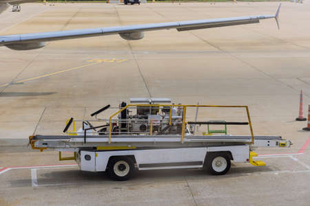 Airport ground service on conveyor belt to an airplane outdoors a daytimeの写真素材
