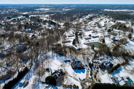 Aerial view of snowed in traditional housing estate in the suburbs in dangerous weather conditionsの写真素材